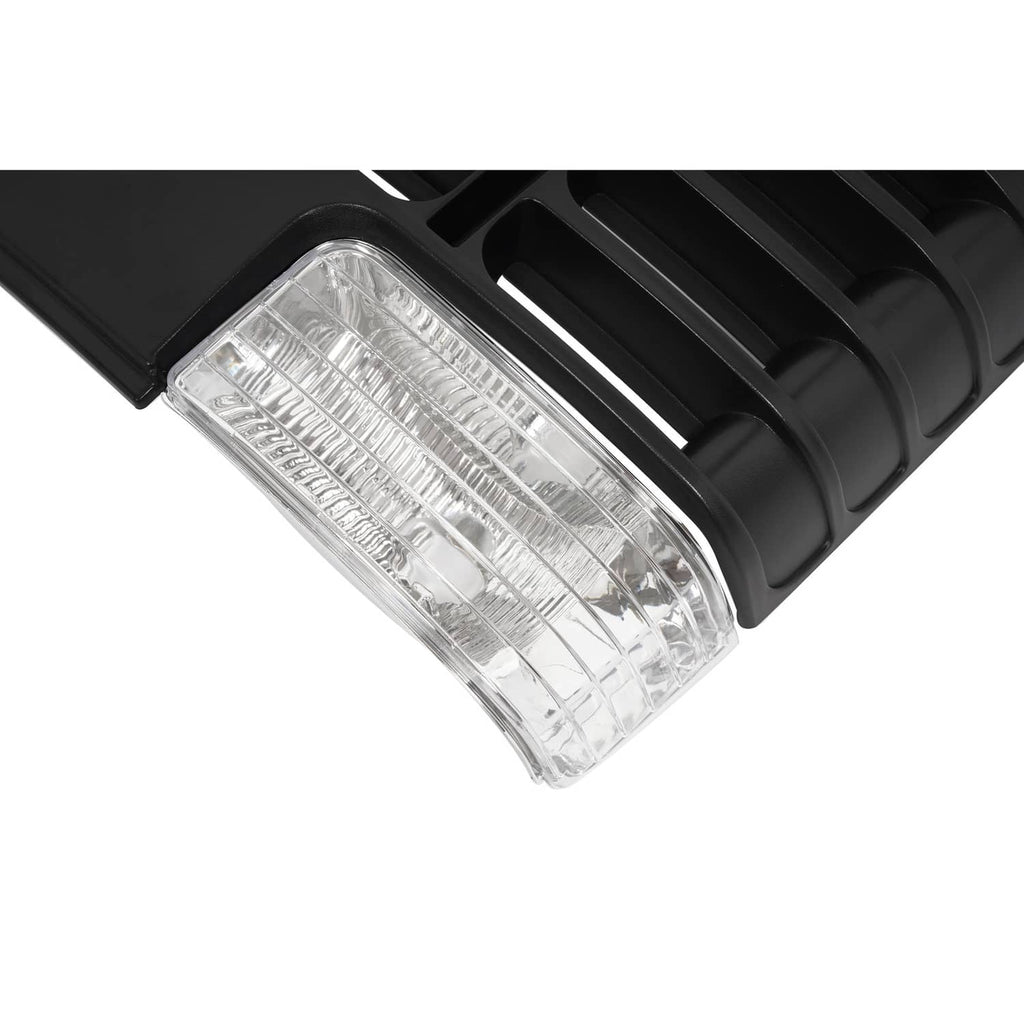Close-up of clear rectangular headlight lens on black grille with vent openings