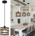 Black cage pendant light with spiral wire frame and warm glass bulb glow