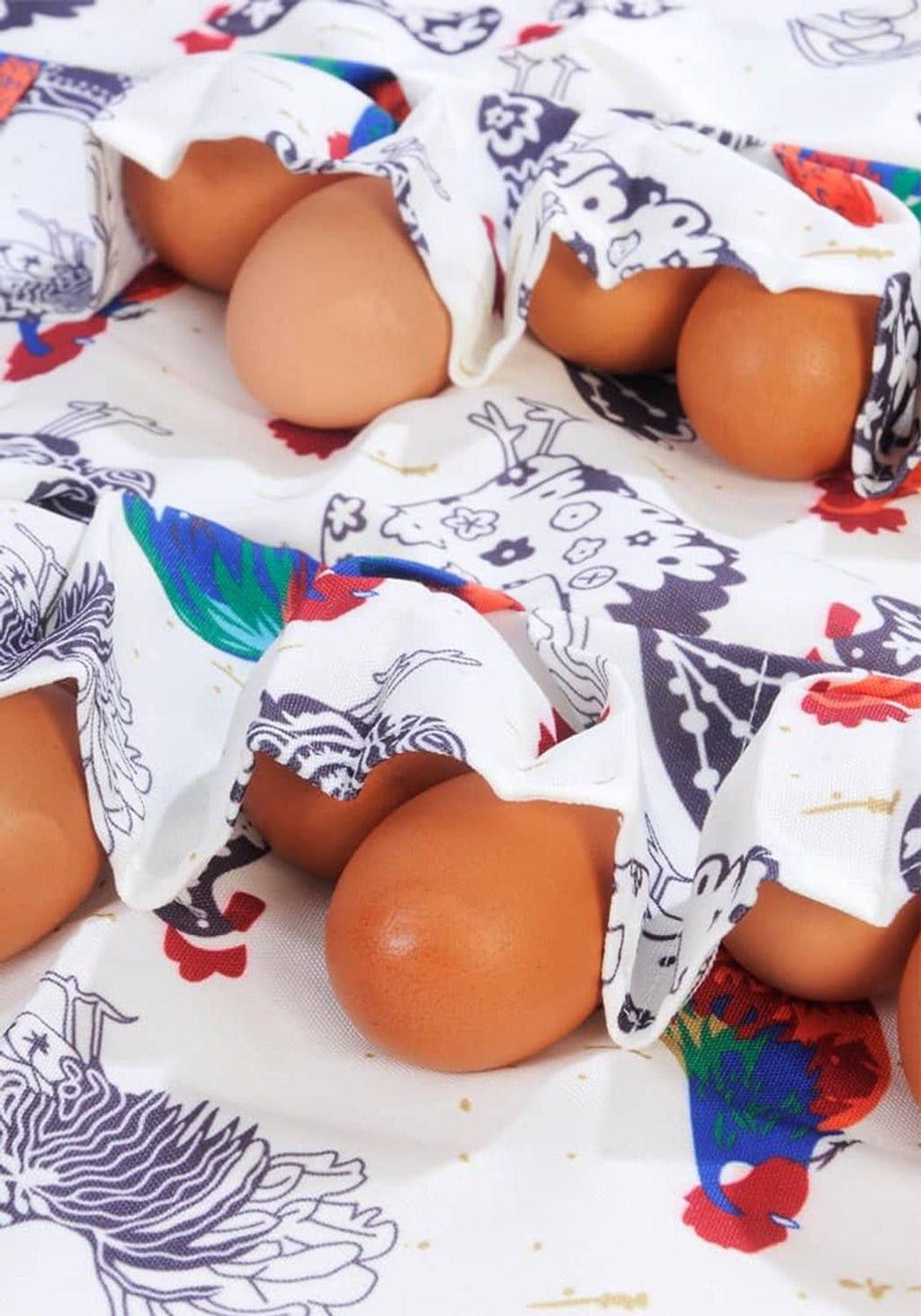 White apron with chicken pattern, eggs tucked into front pockets