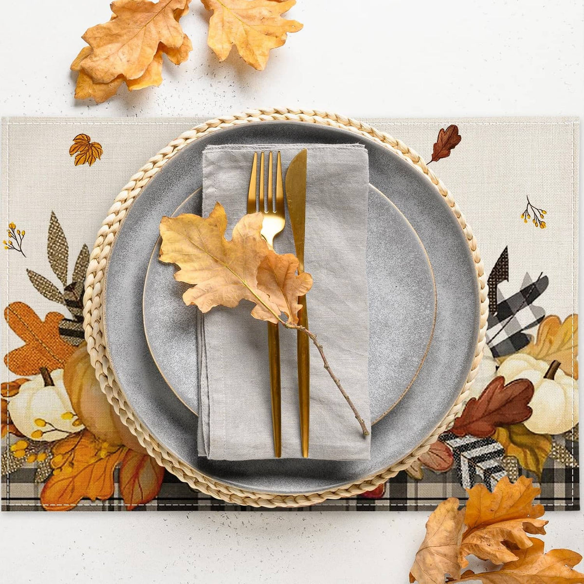 Beige placemat with orange and brown leaves, pumpkins, and plaid accents