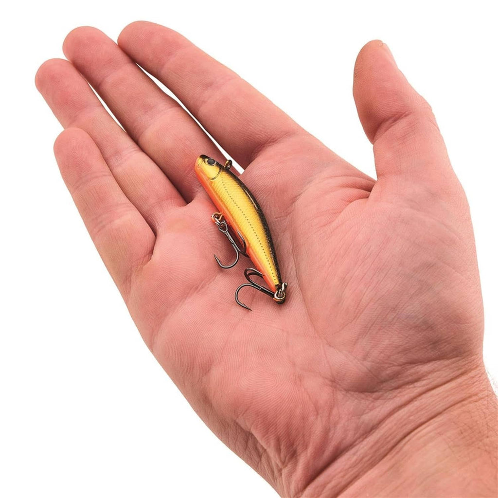 Yellow and black fishing minnow lure held in hand with two treble hooks