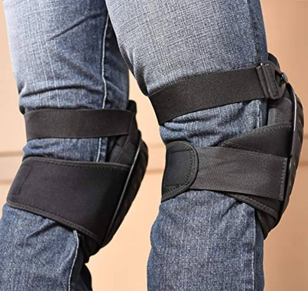 Close-up black knee pad straps and molded cap over denim pant legs