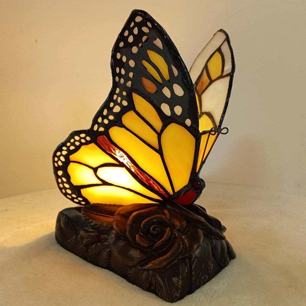 Monarch butterfly accent table lamp glowing amber through yellow stained-glass wings