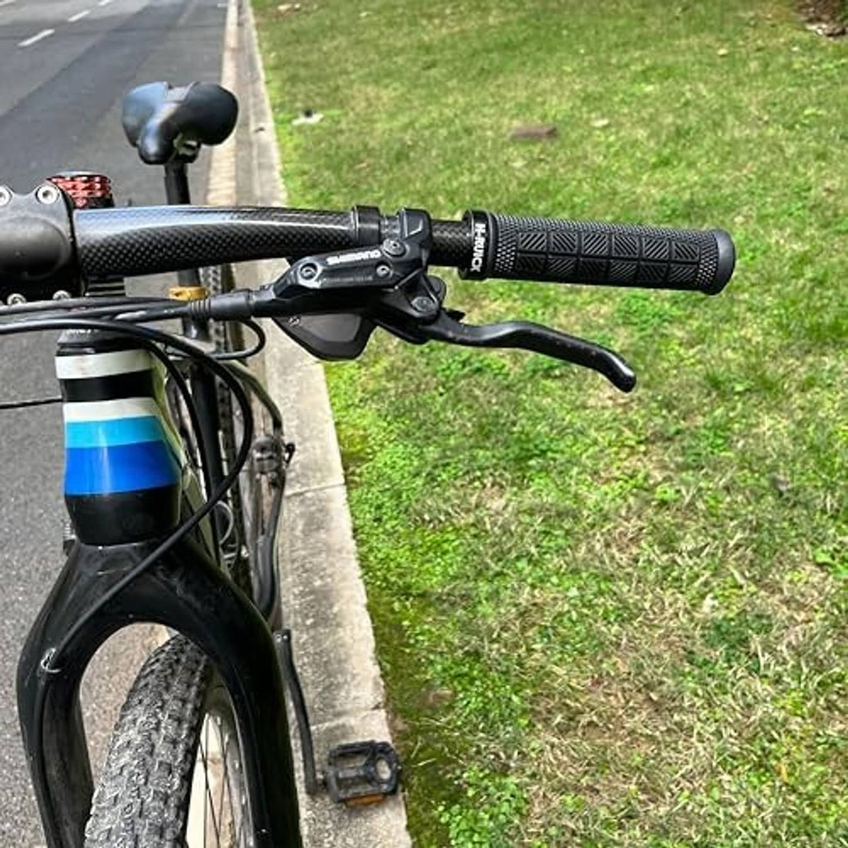 Ergonomic dark bicycle handlebar grips with textured pattern on the handlebar
