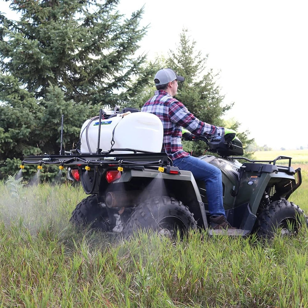 Quad sprayer with white tank and black diaphragm pump assembly in grassy field