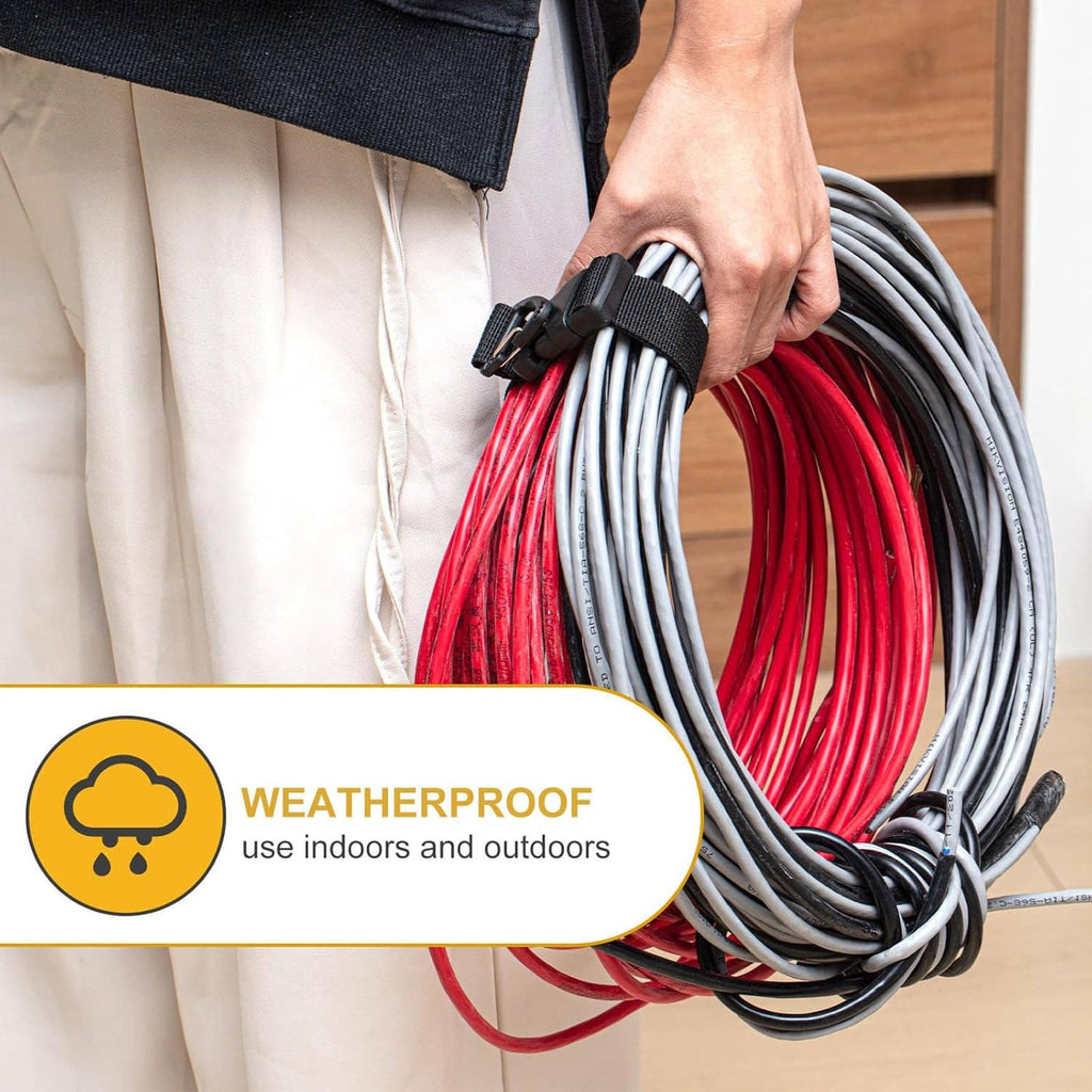 Hand holding a coiled extension cord bundle with black strap and triangle clips