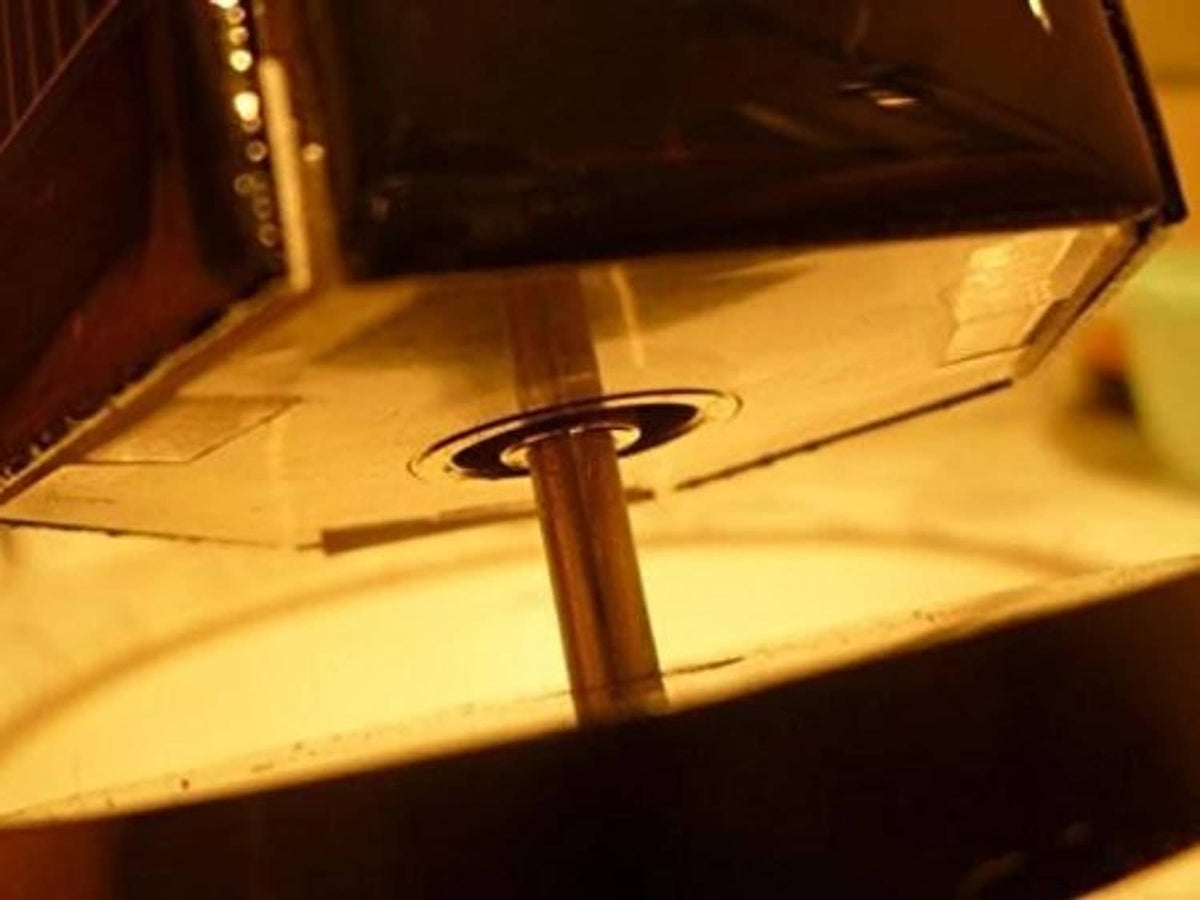 Solar motor toy close-up of copper coil and vertical axle inside the cube housing