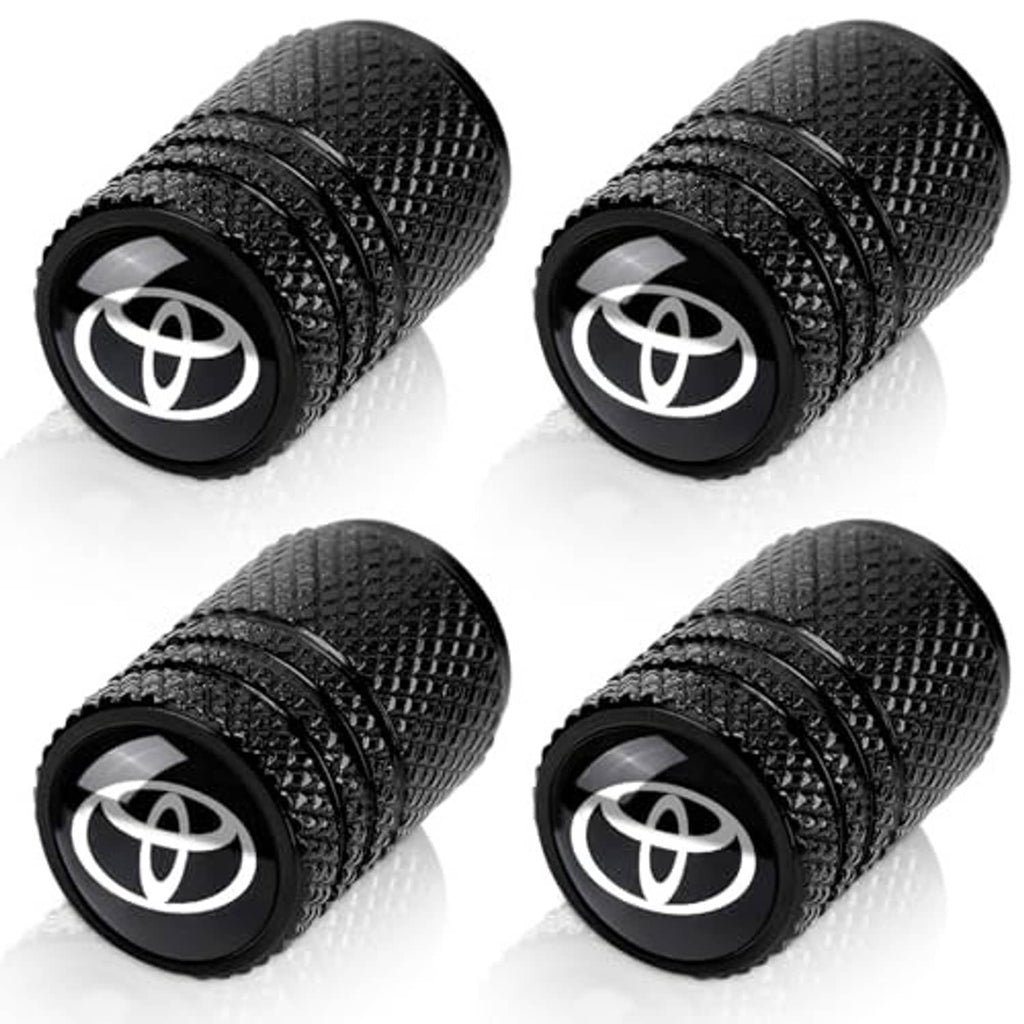 Four black tire valve stem caps with textured grip and Toyota emblem on each end