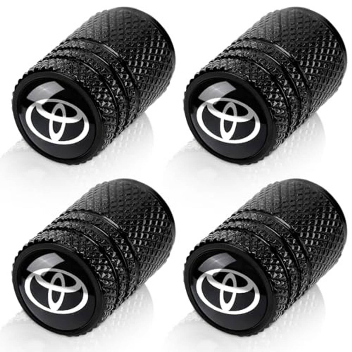 Four black tire valve stem caps with textured grip and Toyota emblem on each end