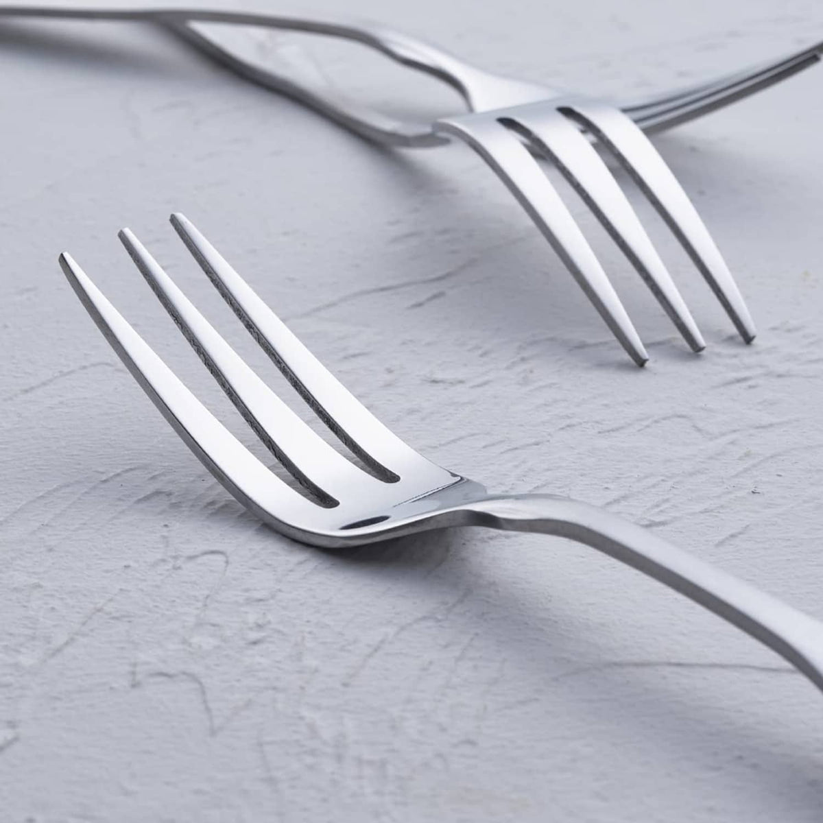 Close-up of polished stainless steel 3-tine dinner fork head and prongs