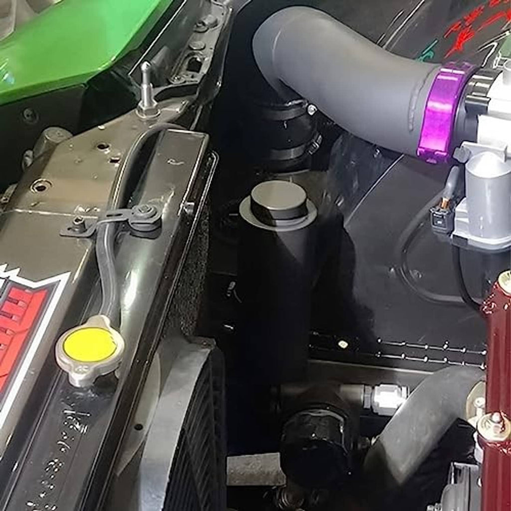 Cylindrical coolant overflow bottle installed in engine bay with connected hoses
