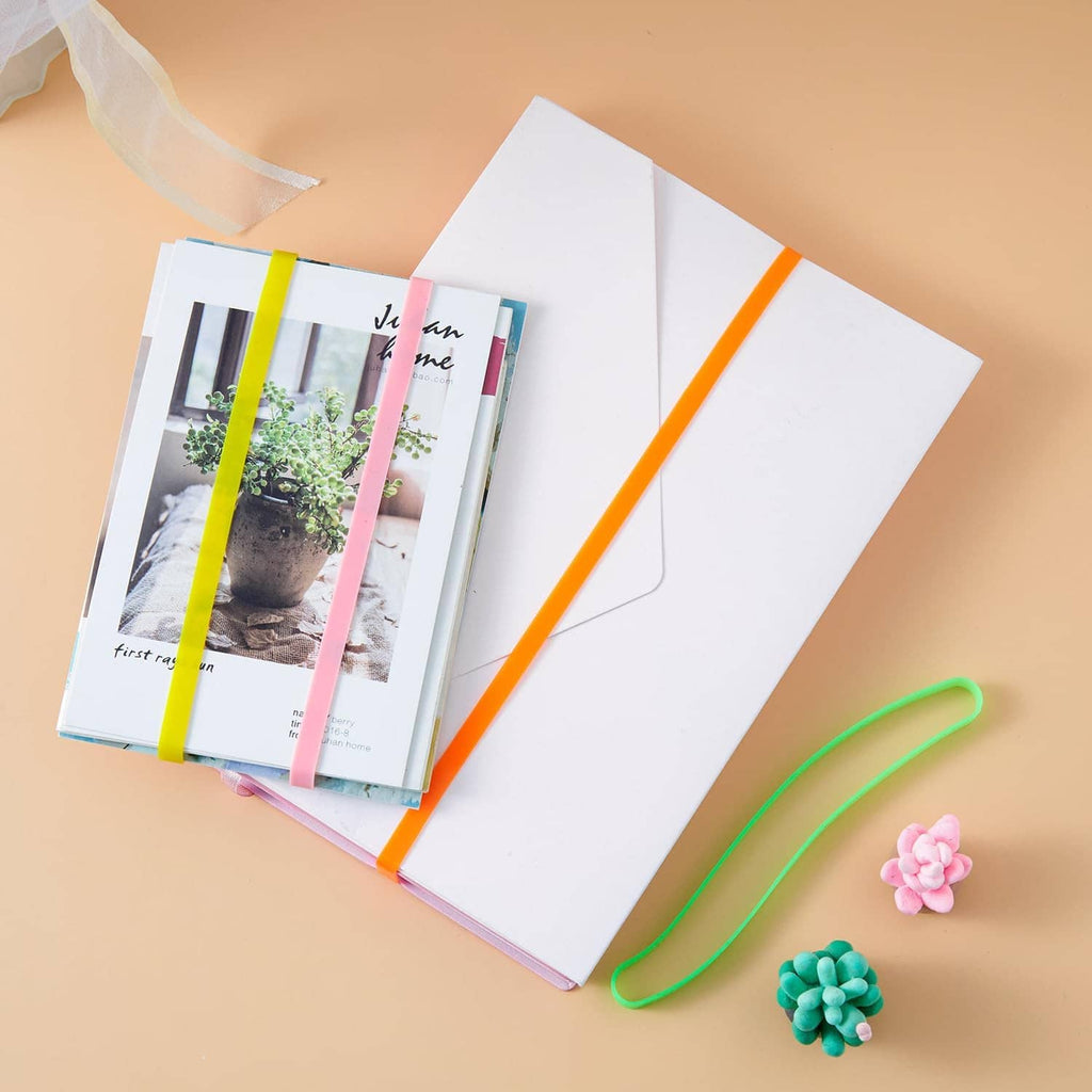 Green silicone elastic band and small accessories near a notebook, curved loop band