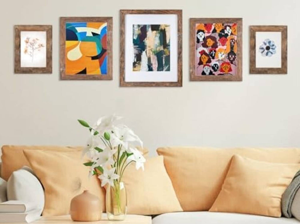 Rustic brown photo frames displayed on a wall above a sofa, multiple sizes
