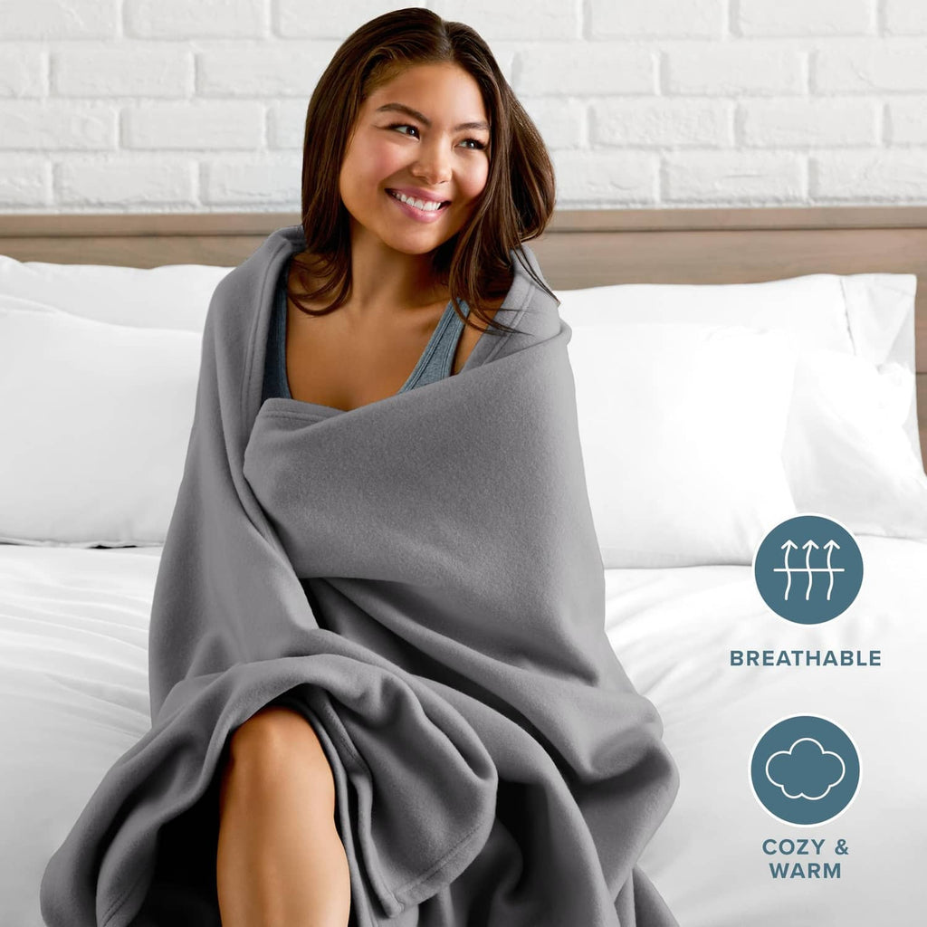 Gray blanket worn as a wrap over shoulders on a bed, cozy and breathable
