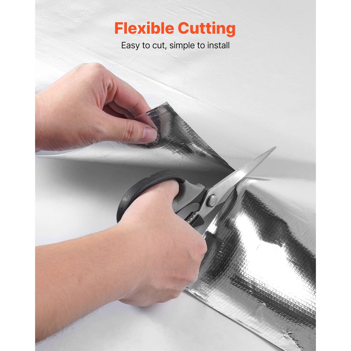Reflective foil insulation being cut with scissors, flexible sheet for easy installation