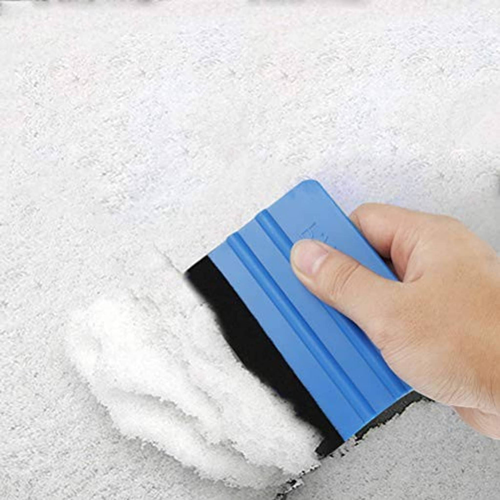 Blue vinyl edge squeegee tool with black felt pad pressed along a surface seam