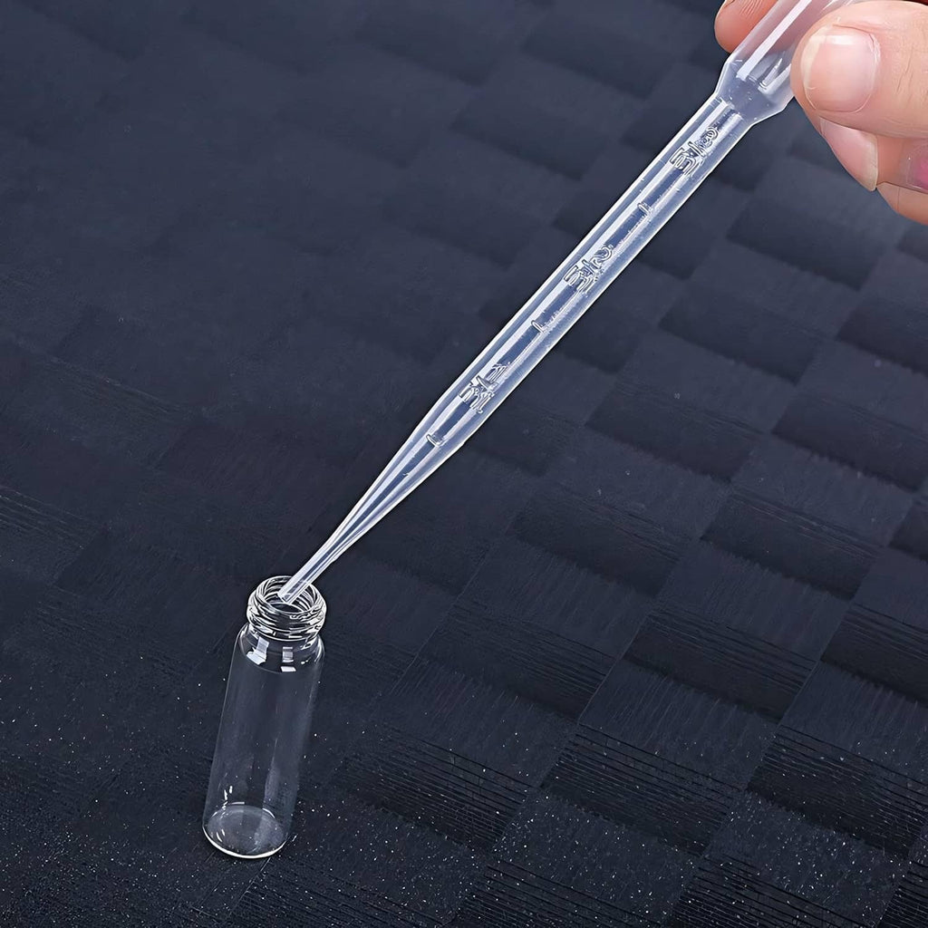 Clear extraction syringe nozzle dispensing into small perfume bottle