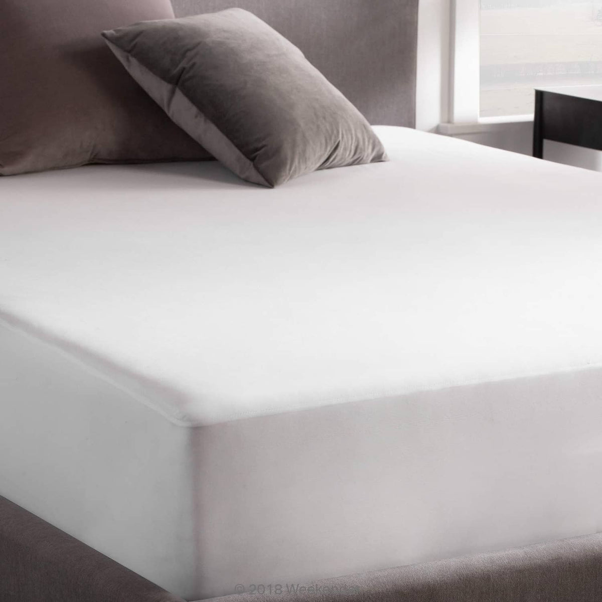 Fitted jersey mattress protector corner with smooth white surface and gray side