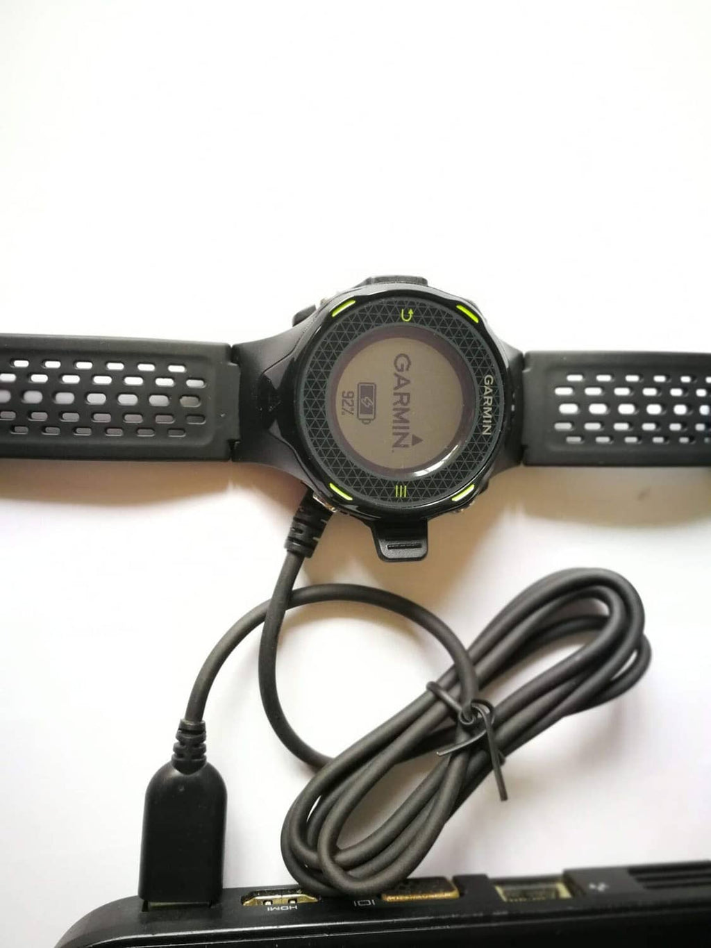 Garmin smartwatch with charging cable and neatly coiled power cord