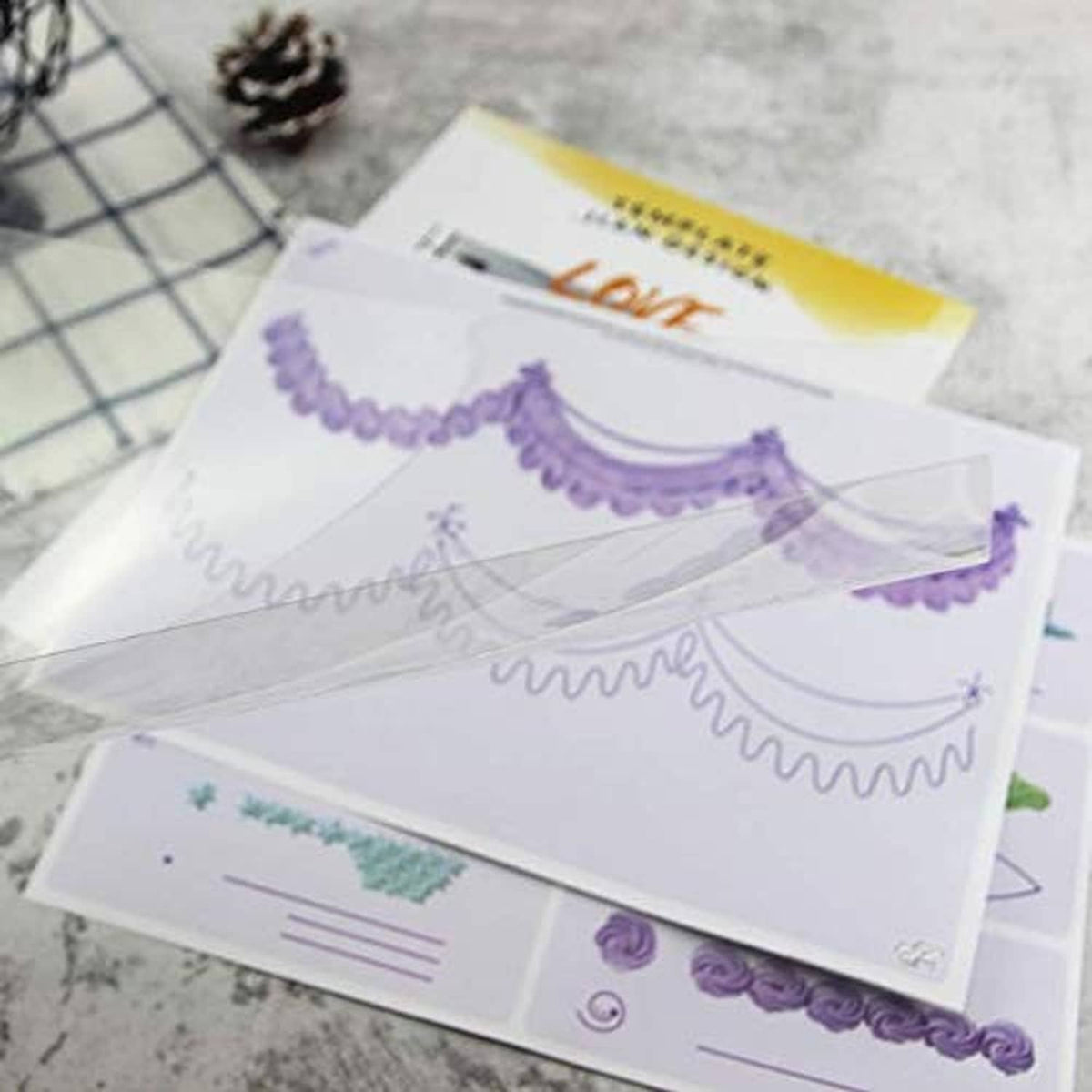 Cake decoration practice cards with purple and green border and ribbon piping patterns