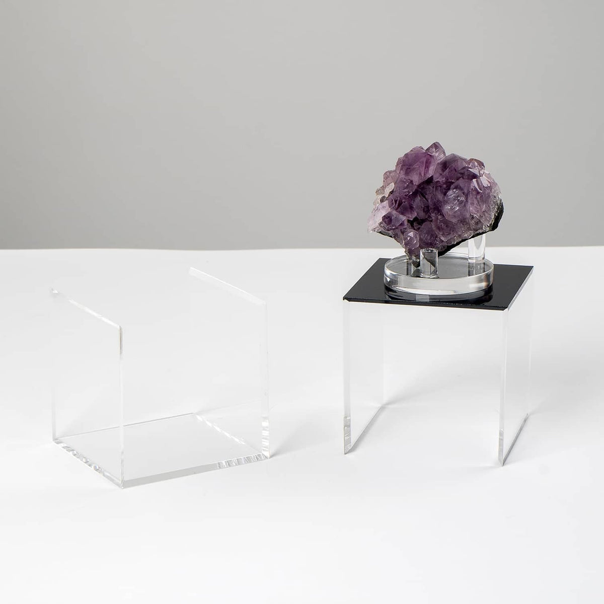 Clear acrylic display box set with open fronts, showing a purple crystal on a base