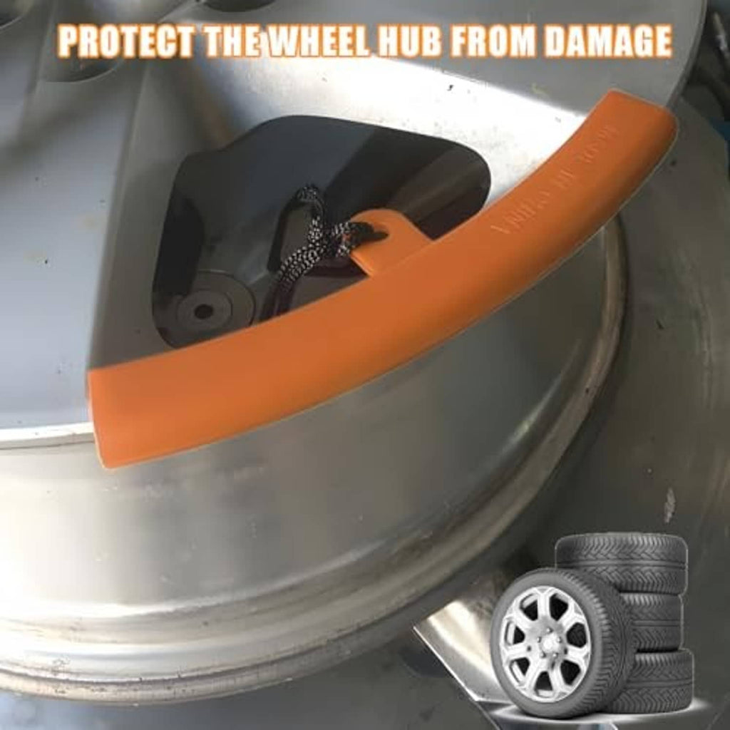Orange curved rim protector on a car wheel hub area, with yellow cord.