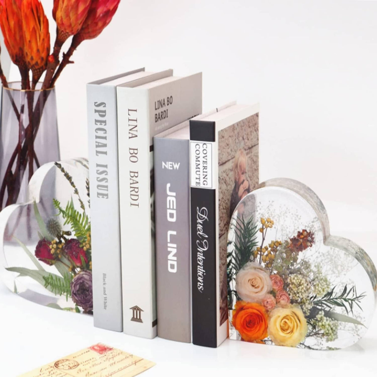 Heart-shaped decorative display with dried flowers beside stacked books