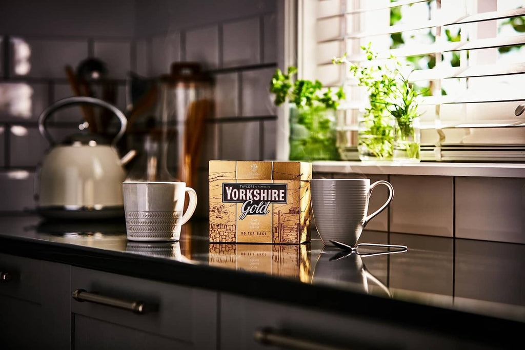 Yorkshire Gold tea bag box with mugs on kitchen counter