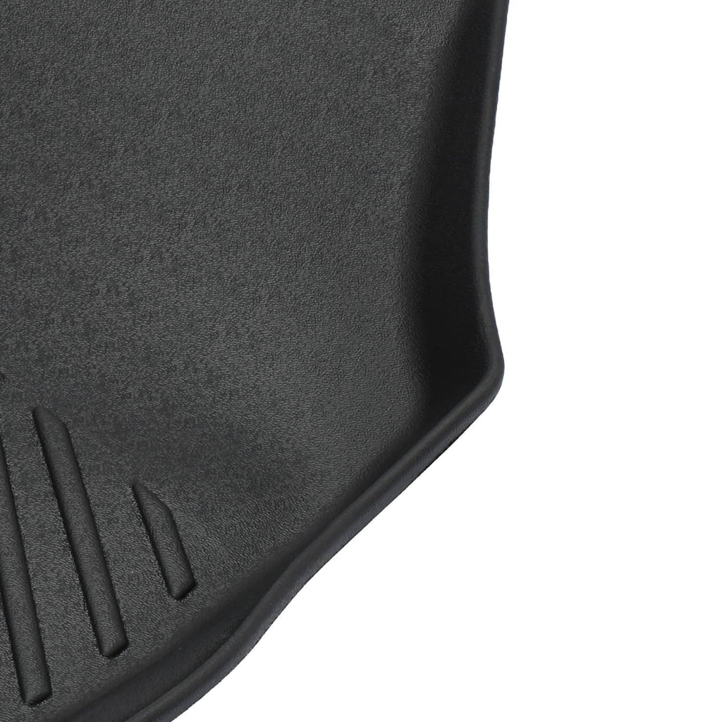 Close-up corner of black rubber floor mat showing raised edge and grooves