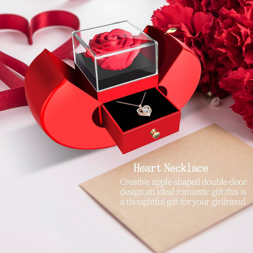 Preserved red rose in clear heart-shaped box with heart necklace on black cushion