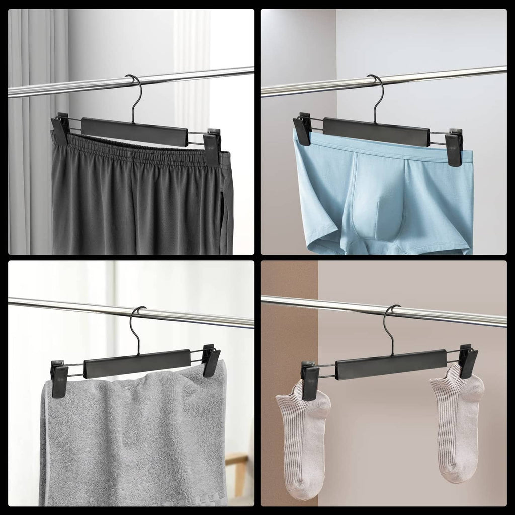 Black pants hanger with clips holding gray, blue, and white garments on a bar
