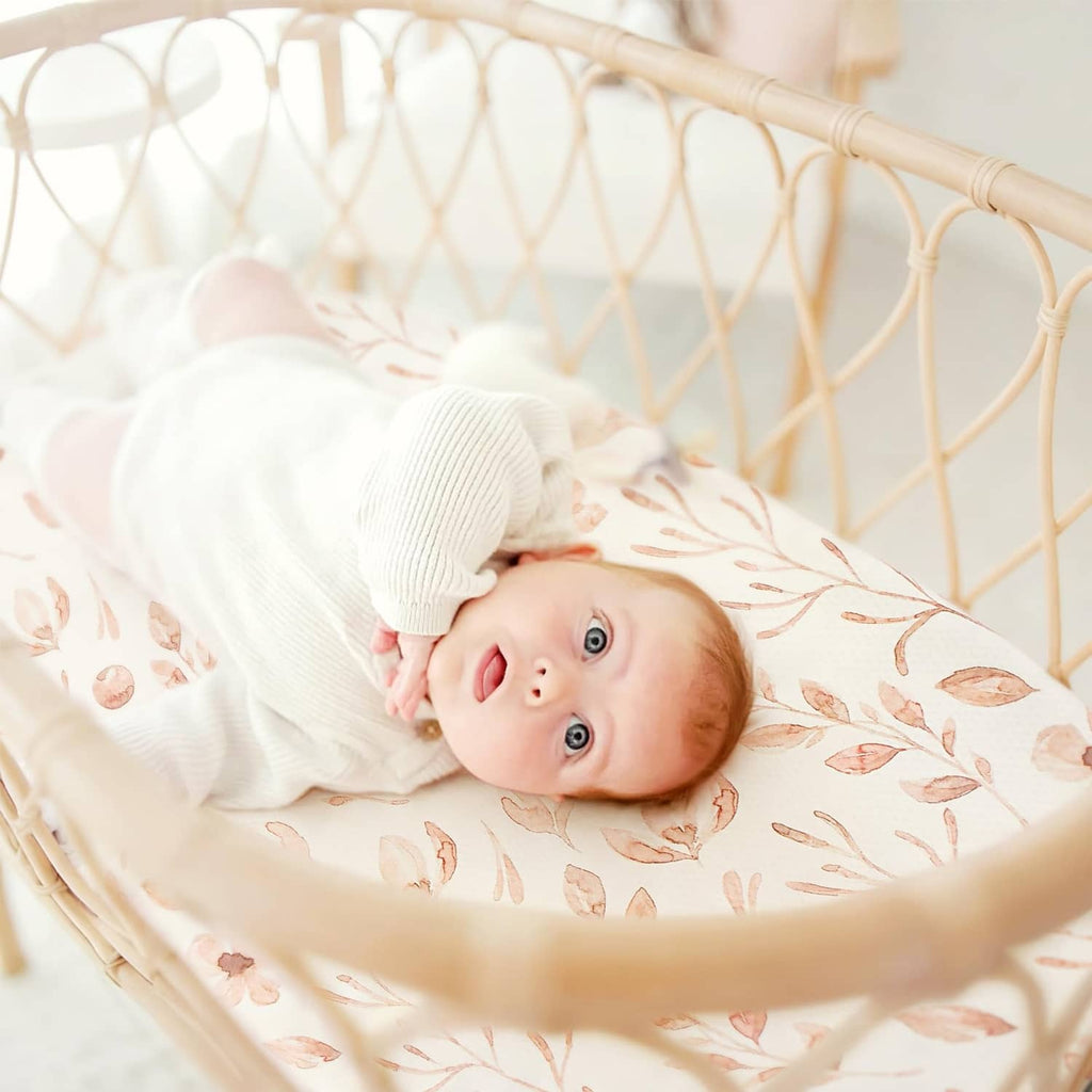 Blush floral woodland fitted bassinet sheet covering baby
