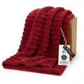 Red twin blanket with plush ridged texture, neatly folded with soft nap
