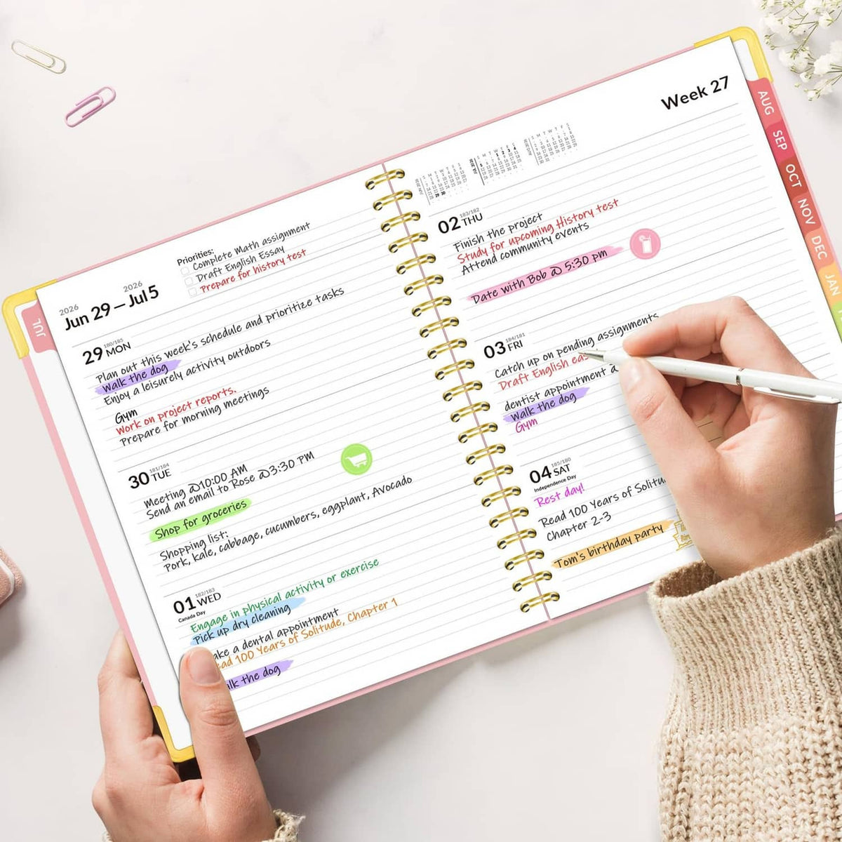 Open weekly planner page with hand writing, highlighted tasks and dates