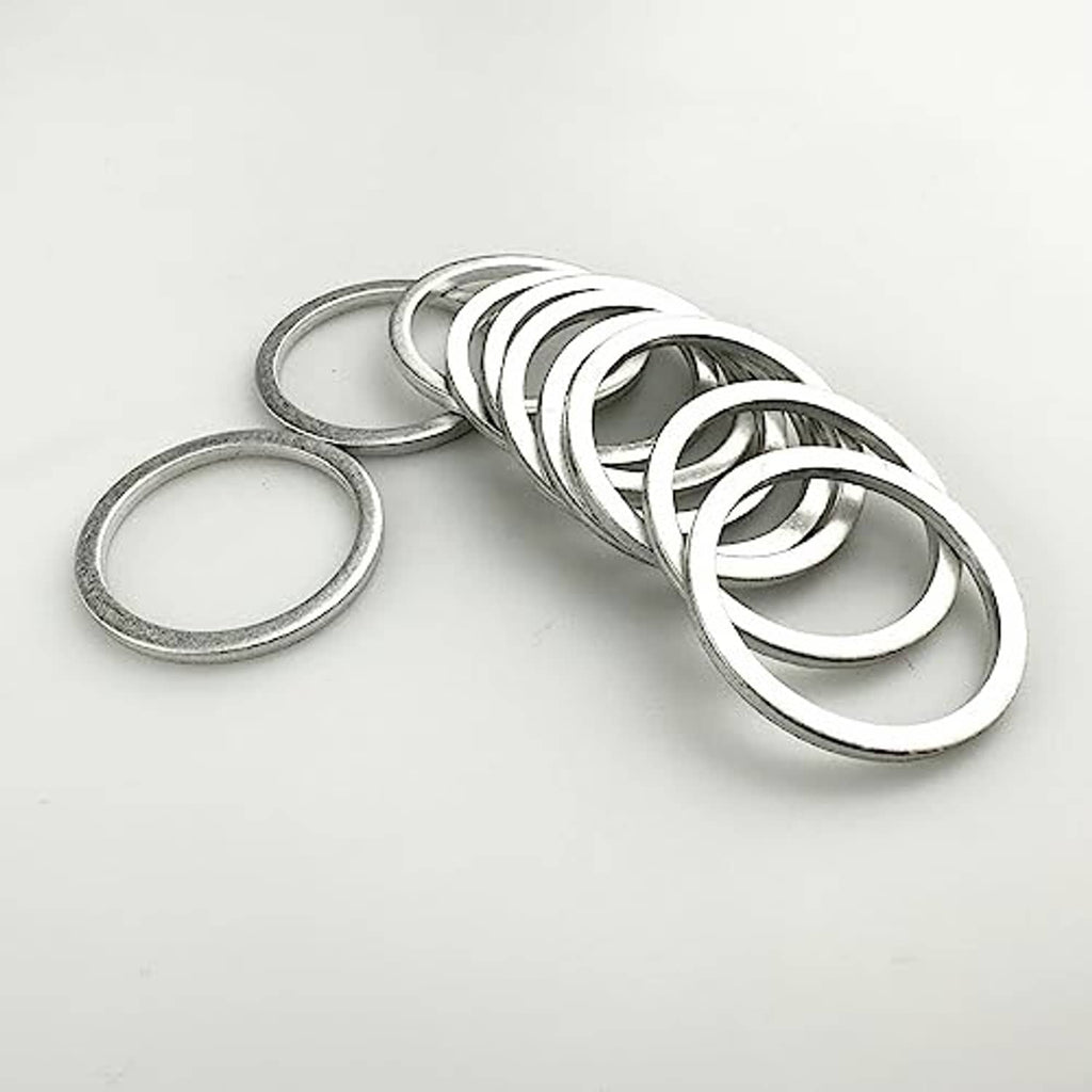 Set of silver aluminum oil drain plug gaskets (washers) stacked and laid on white surface