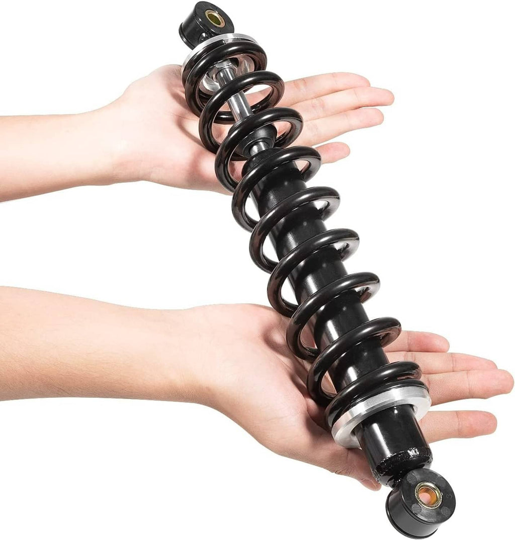 Two front shock absorbers held in hands, black coils with silver mounting hardware