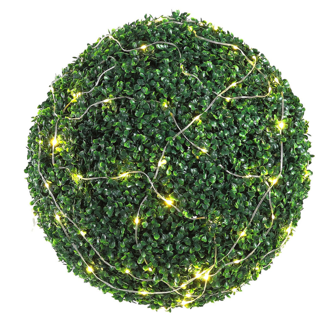 Artificial green topiary ball wrapped with warm white string lights, faux plant