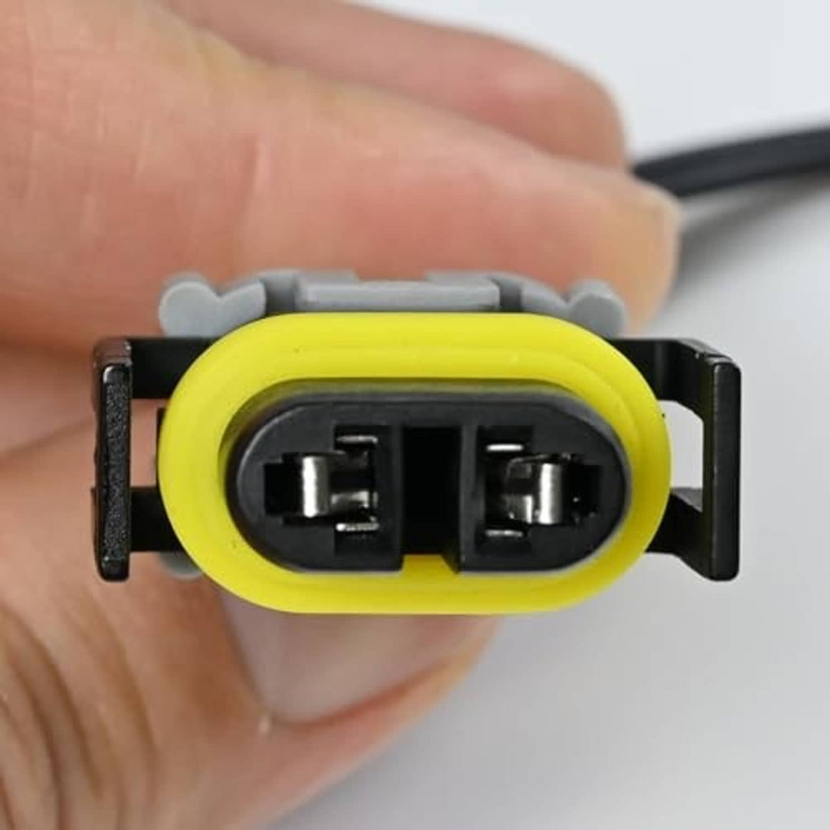 Headlight connector pigtail socket with yellow seal, grey housing, and two metal terminals