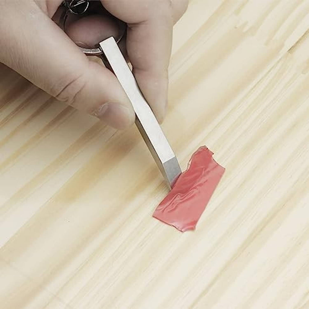 Mini prybar lifting a red seal from a surface