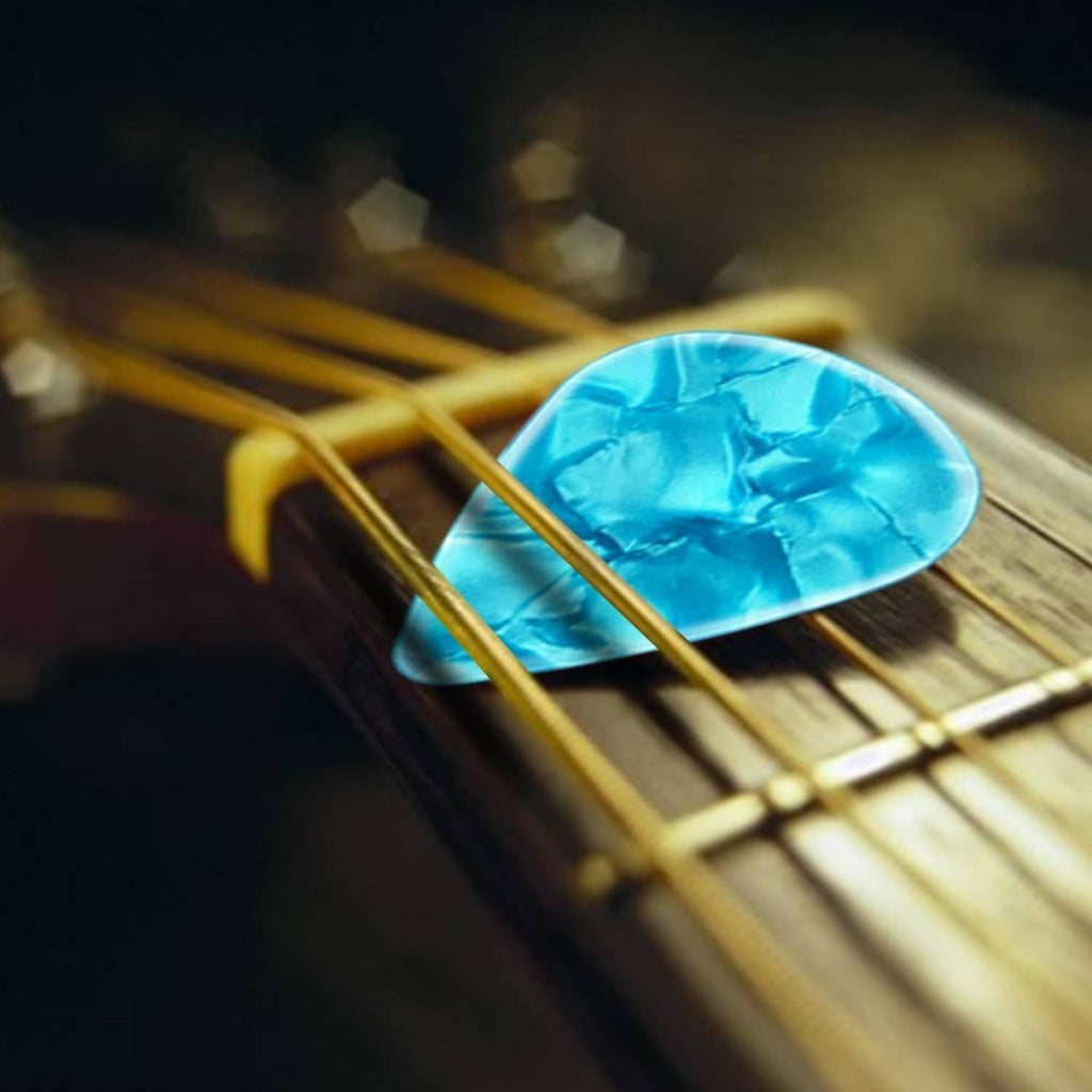 Blue guitar pick resting on guitar strings and frets