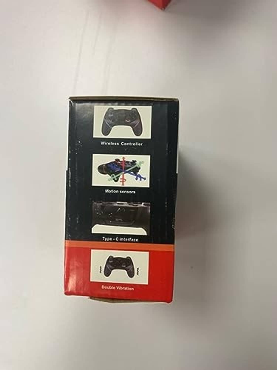 Wireless game controller retail box showing black controller and sensor icons