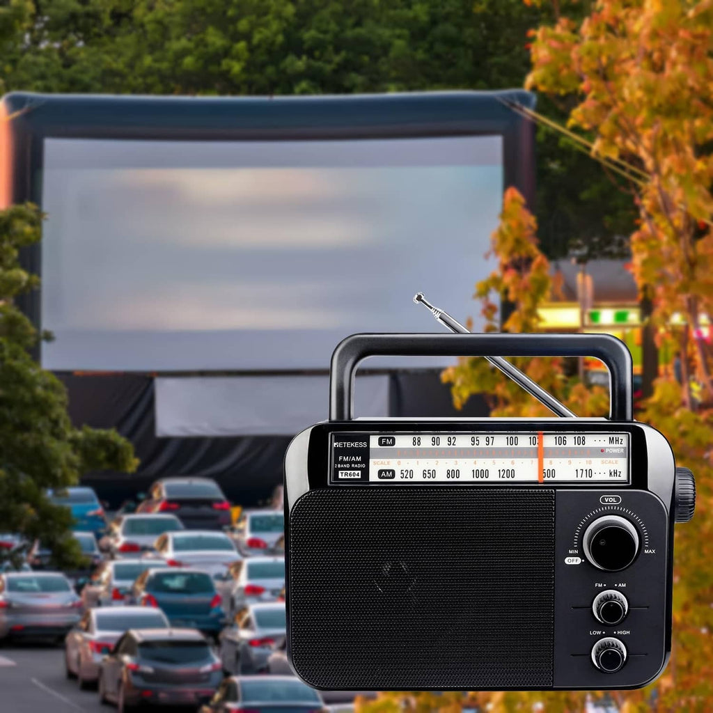 Portable AM/FM radio outdoors on a surface with the long antenna extended