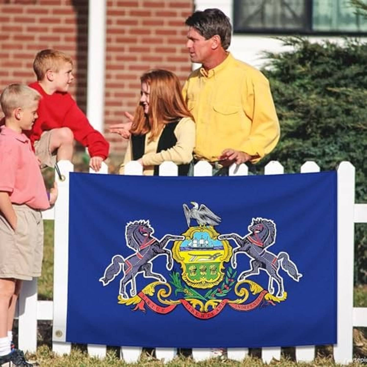 Blue embroidered Pennsylvania state flag on fence with coat of arms and two horses