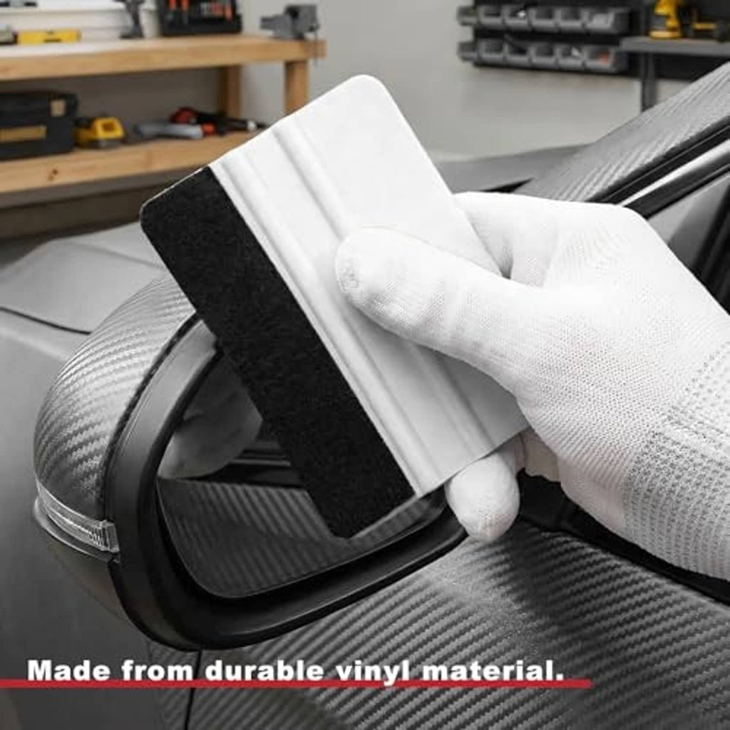 Plastic felt edge squeegee with white handle and black felt pad beside vinyl roll