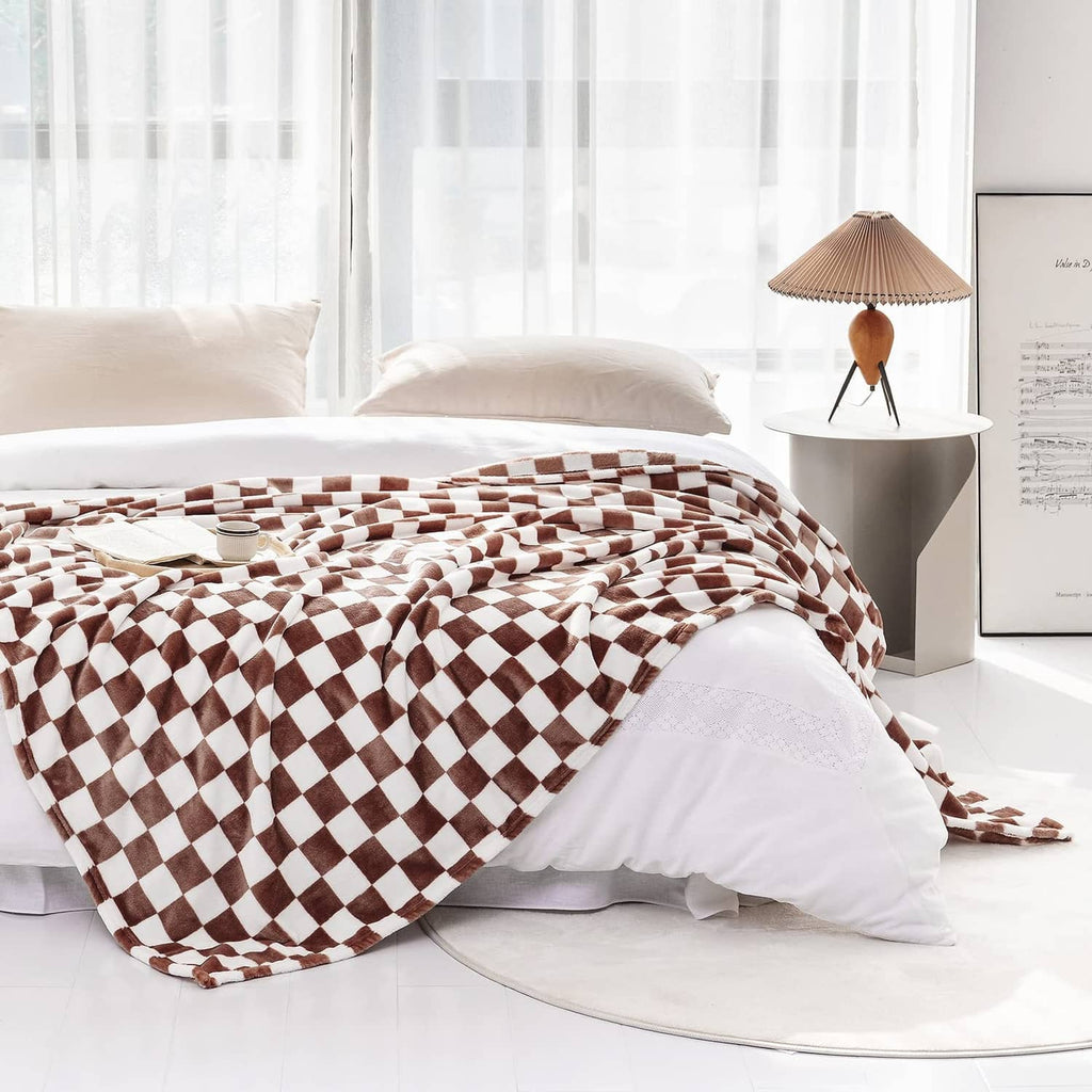 Checkerboard flannel throw blanket spread on bed in coffee-brown and white