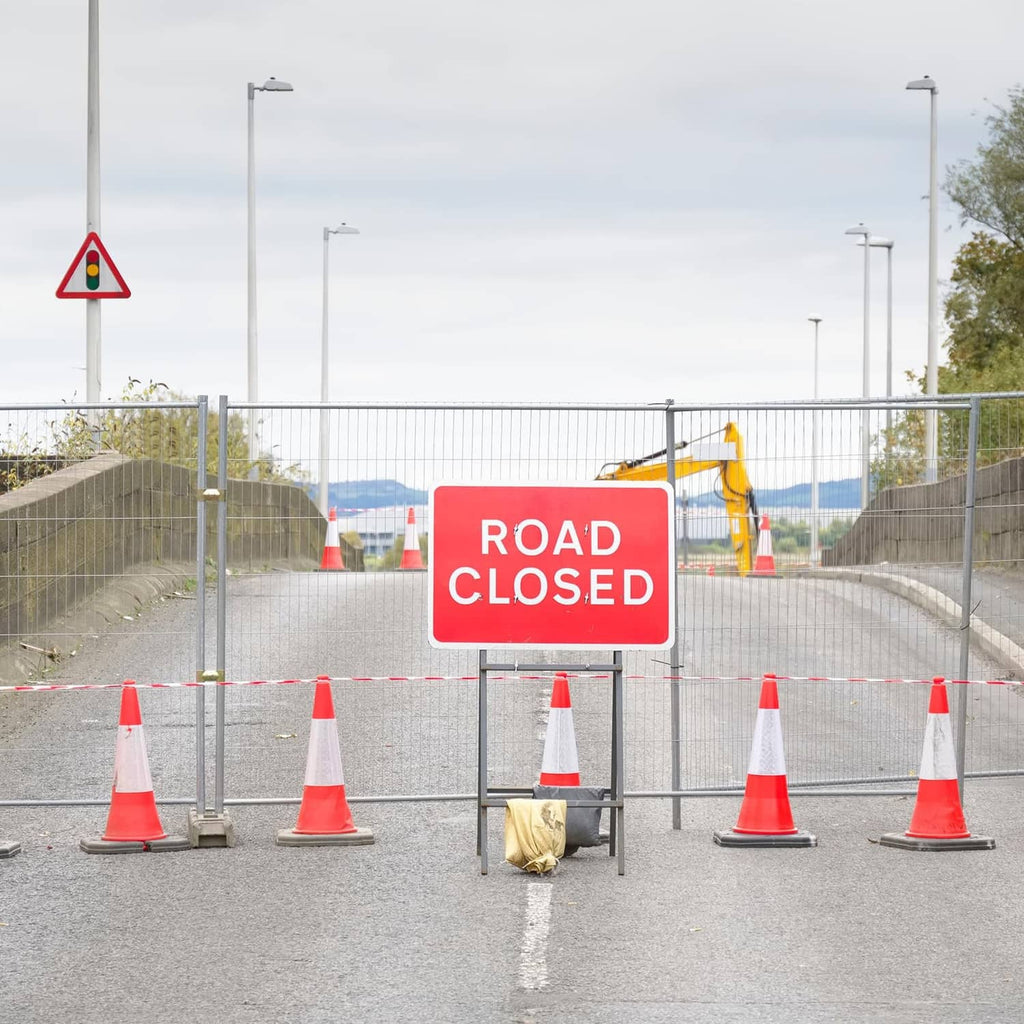 Road closed barrier with plastic chain links and orange cones