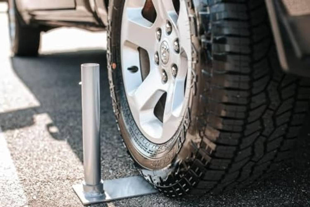 Tire-mounted flagpole post with rectangular base on vehicle wheel