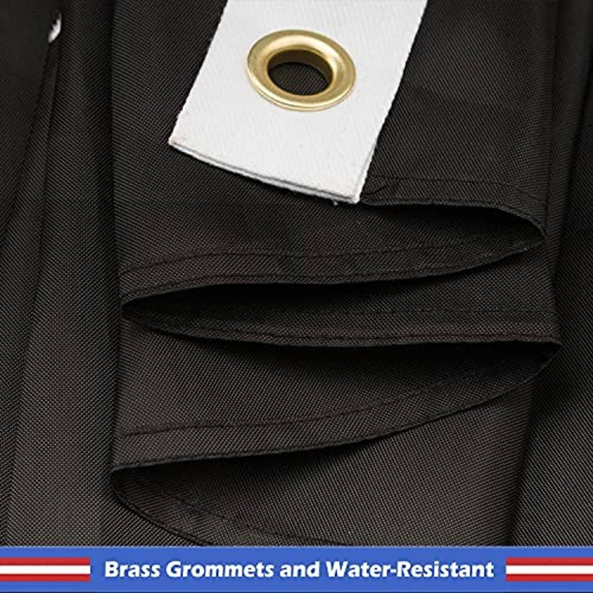 Embroidered POW-MIA flag grommet tab close-up with brass eyelet and folded hem