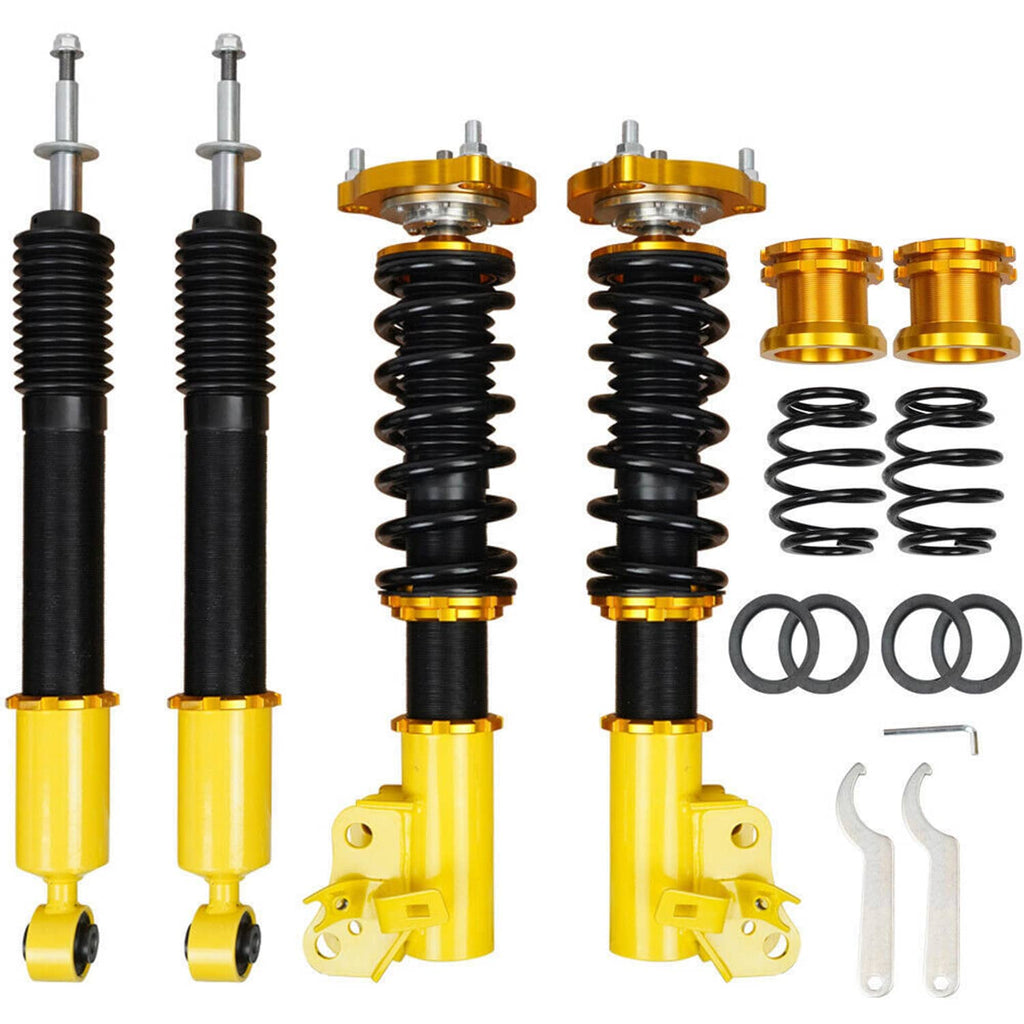 Adjustable coilover suspension kit: two black strut shocks, gold mounts, yellow cylinders