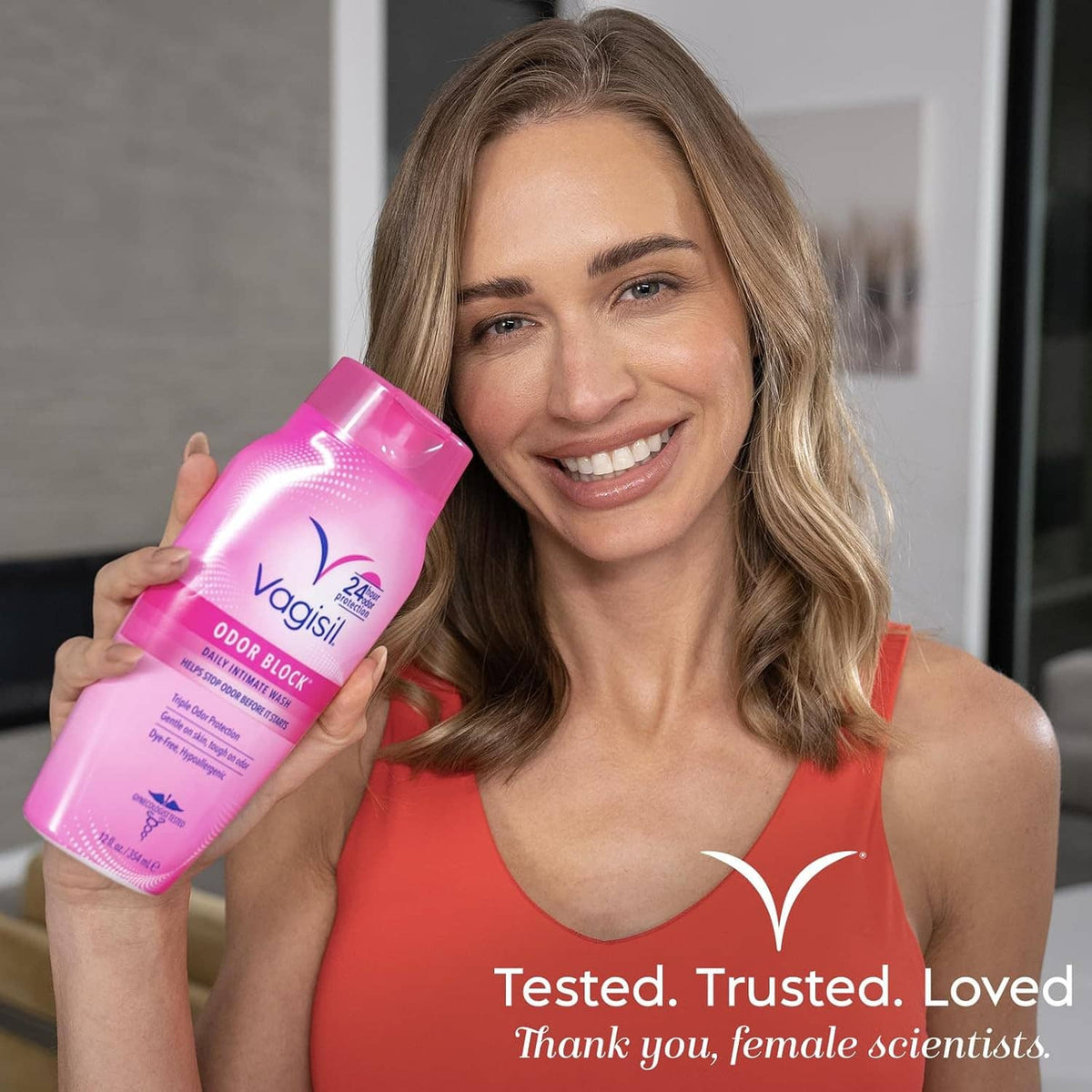Vagisil Odor Block intimate wash pink bottle held by smiling woman
